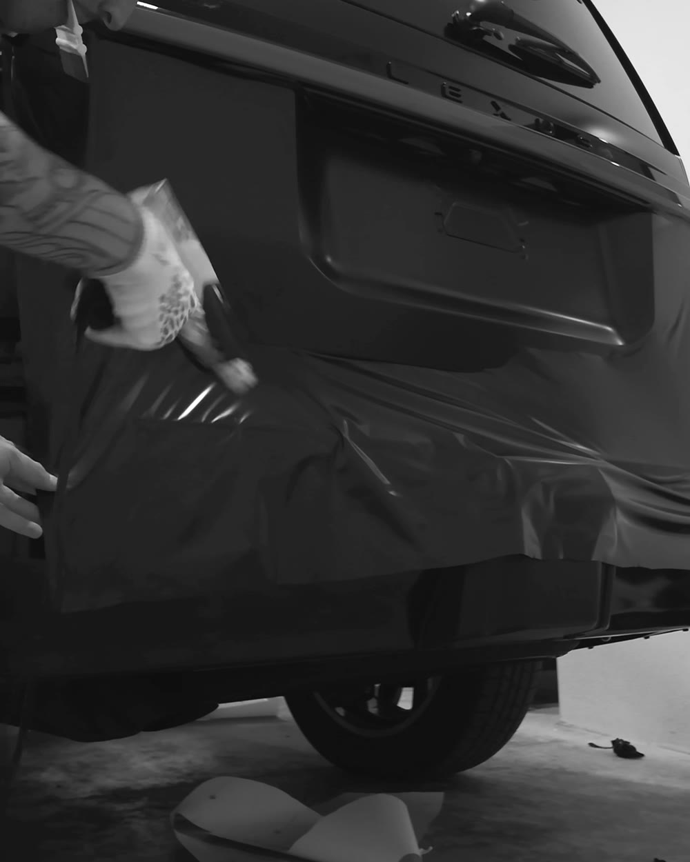 Film being stretched and formed around the bumper by hand